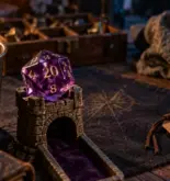 D20 en résine translucide violet sur tapis de dés, guide résine métal pierre